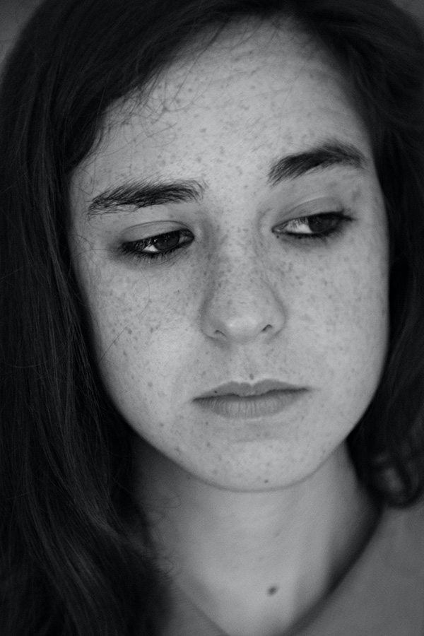 A monochrome image of a freckled woman, showcasing her unique beauty in black and white.