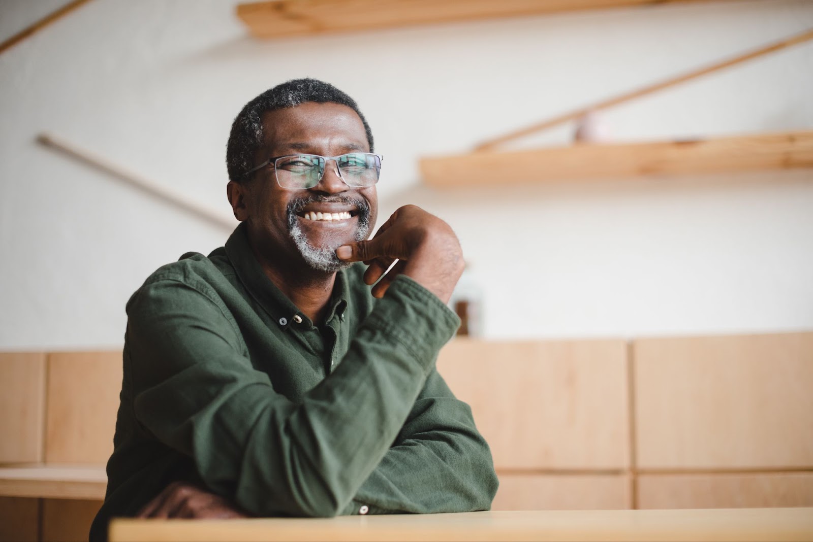 A black man with a smile sits at a table possibly discussing brain mapping and mental health disorders.