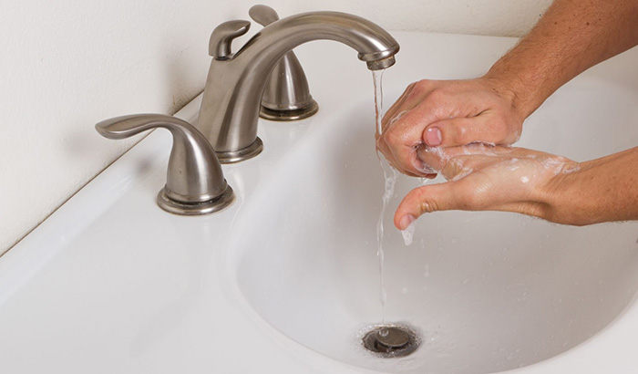 A person with OCD and anxiety undergoing TMS therapy washes their hands meticulously.