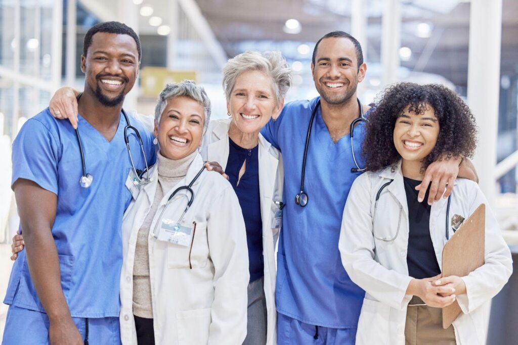 A group of doctors in white coats standing together in a hospital hallway