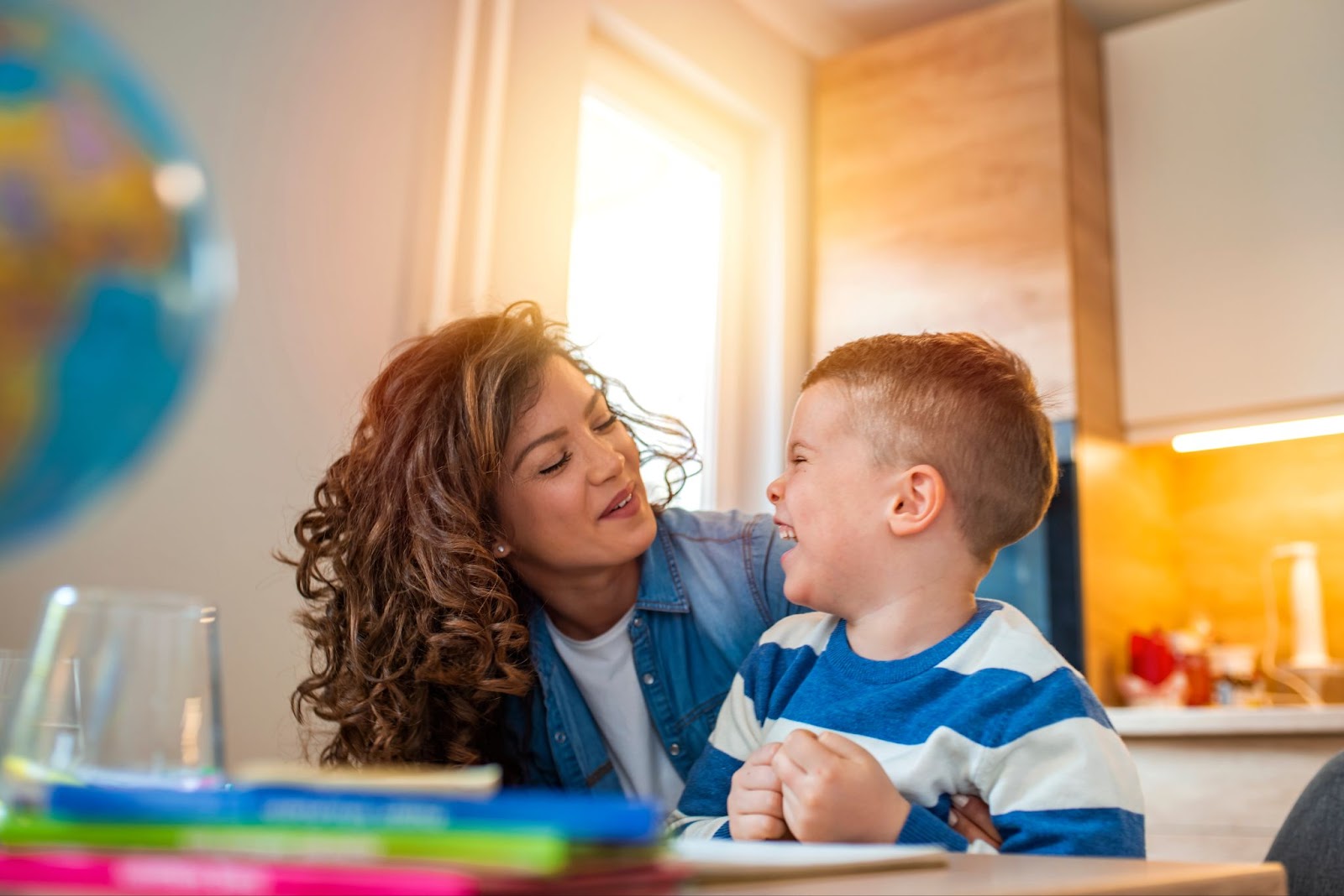 A woman and a boy sitting at a table with a globe, TMS therapy, autism, autism spectrum disorder.