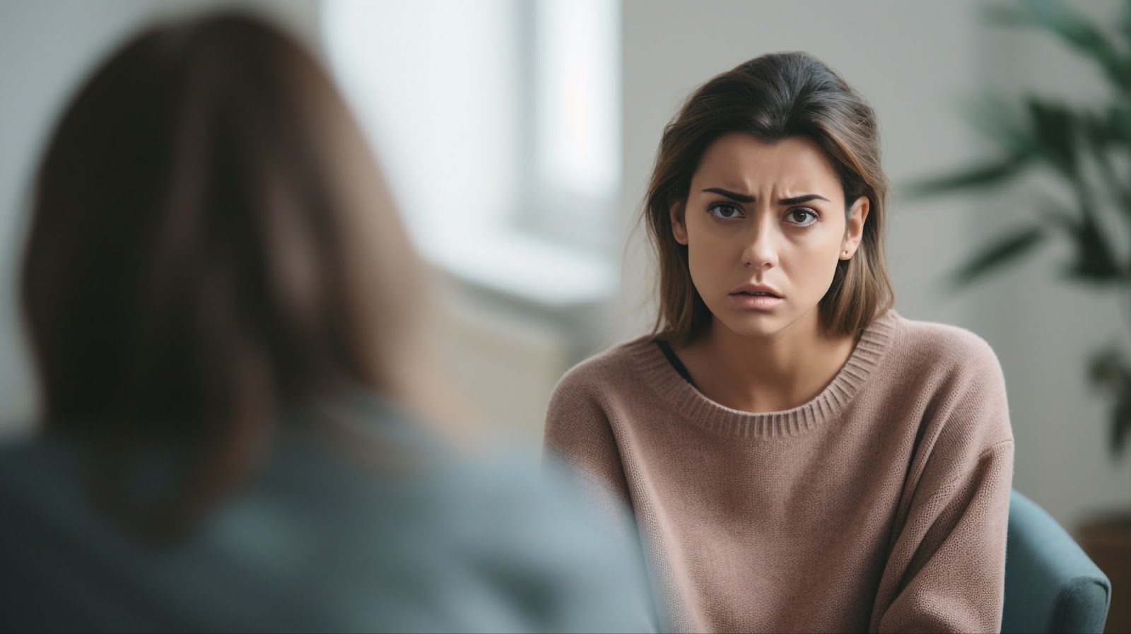 A woman discusses TMS therapy with another woman, focusing on managing bipolar disorder and manic episodes.