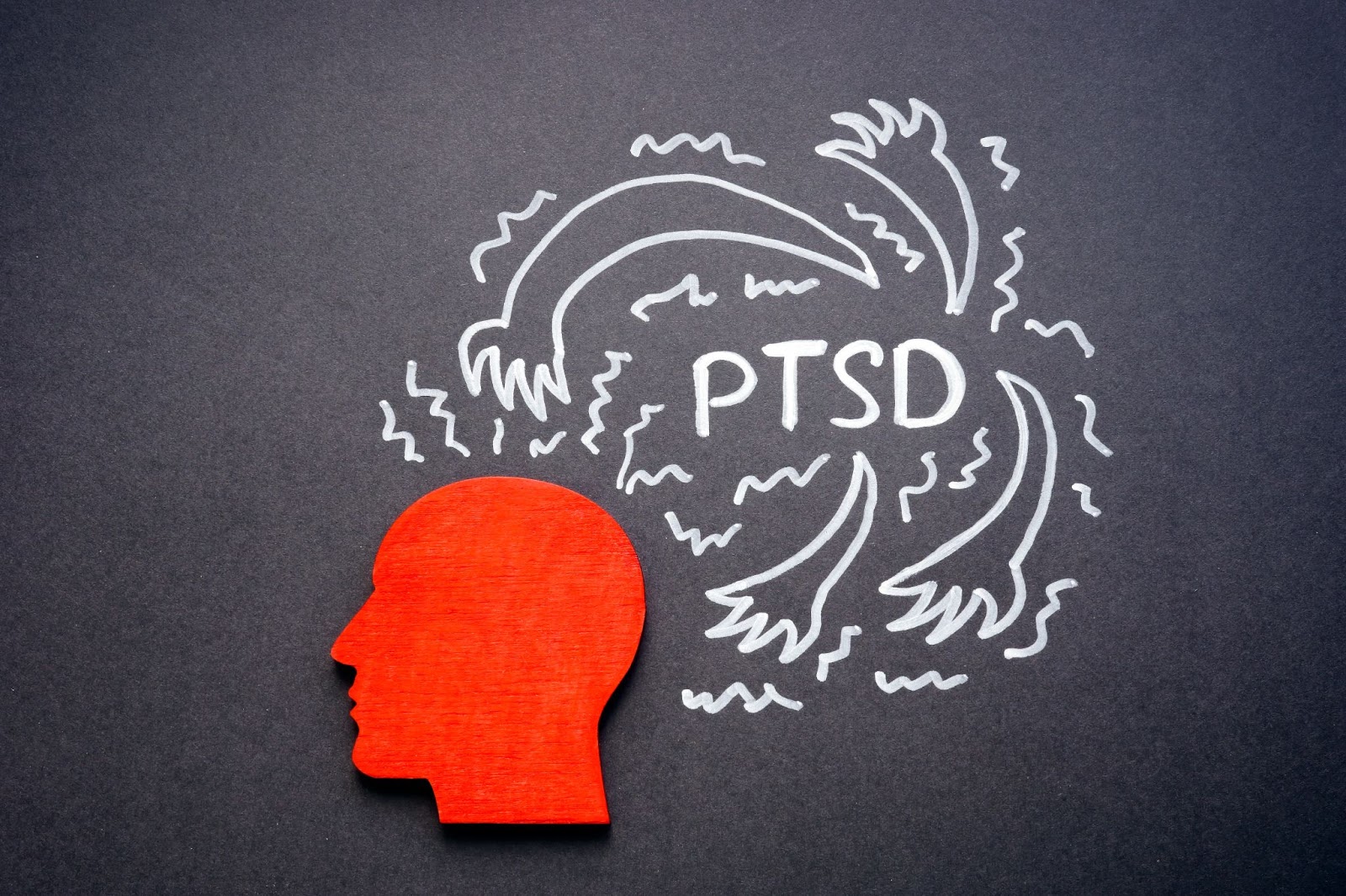 Image of a head with hands and chalk outlines, representing PTSD and mental health concepts, focusing on TMS therapy's role.