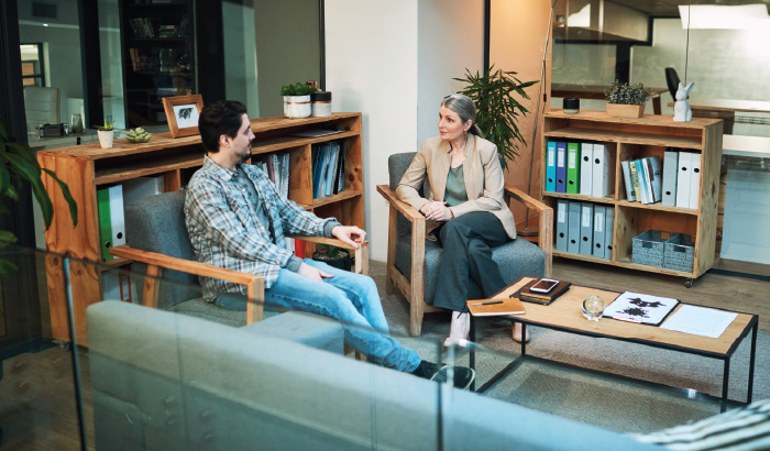 A patient sits in an office with their mental health provider.