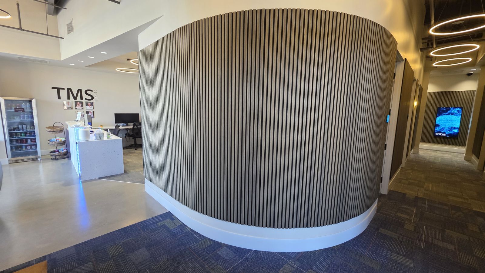  A circular hallway in wood color with a desk inside 