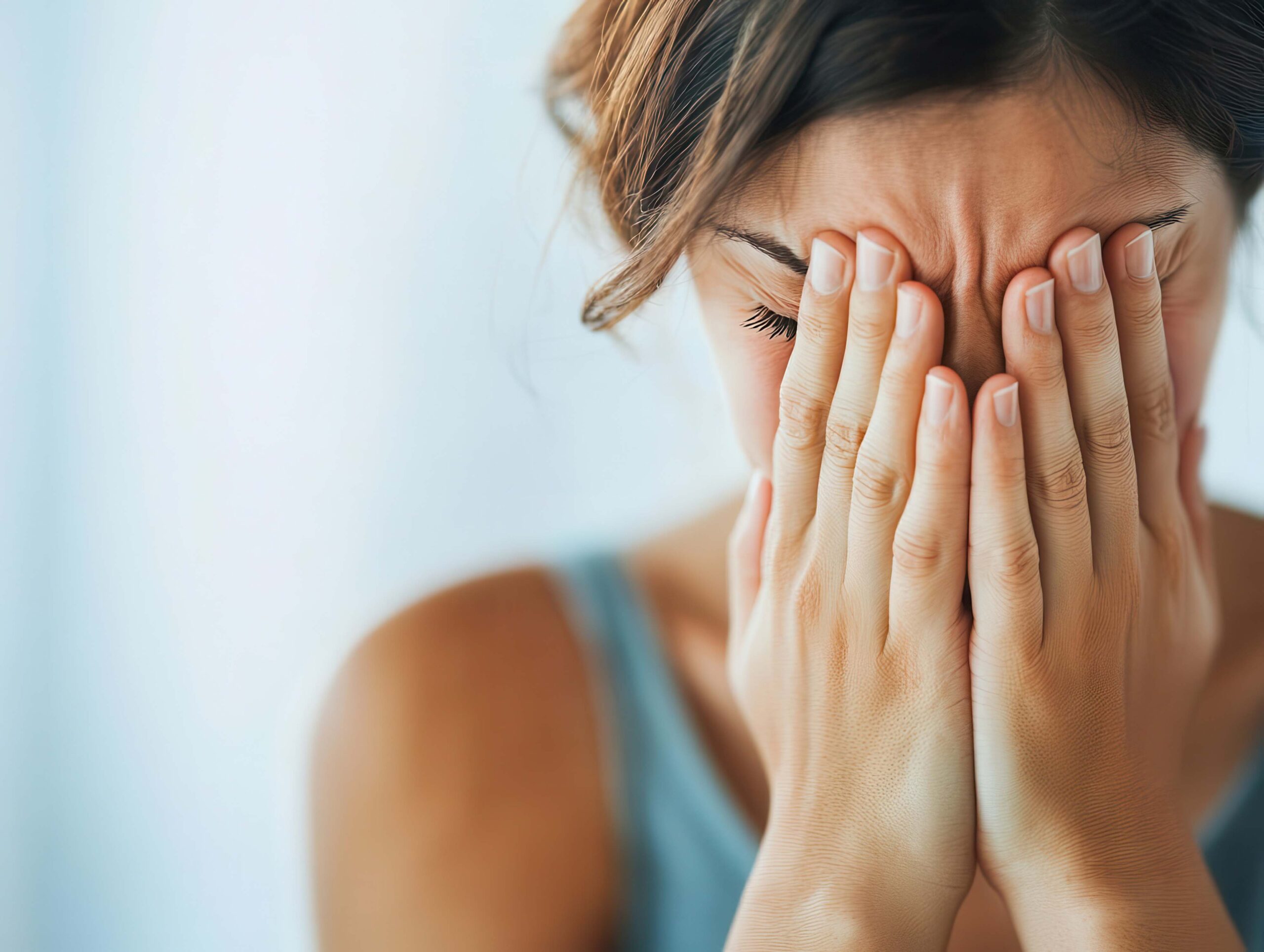 A man sits on a couch, openly discussing mental health with his male therapist as part of his TMS therapy treatment.